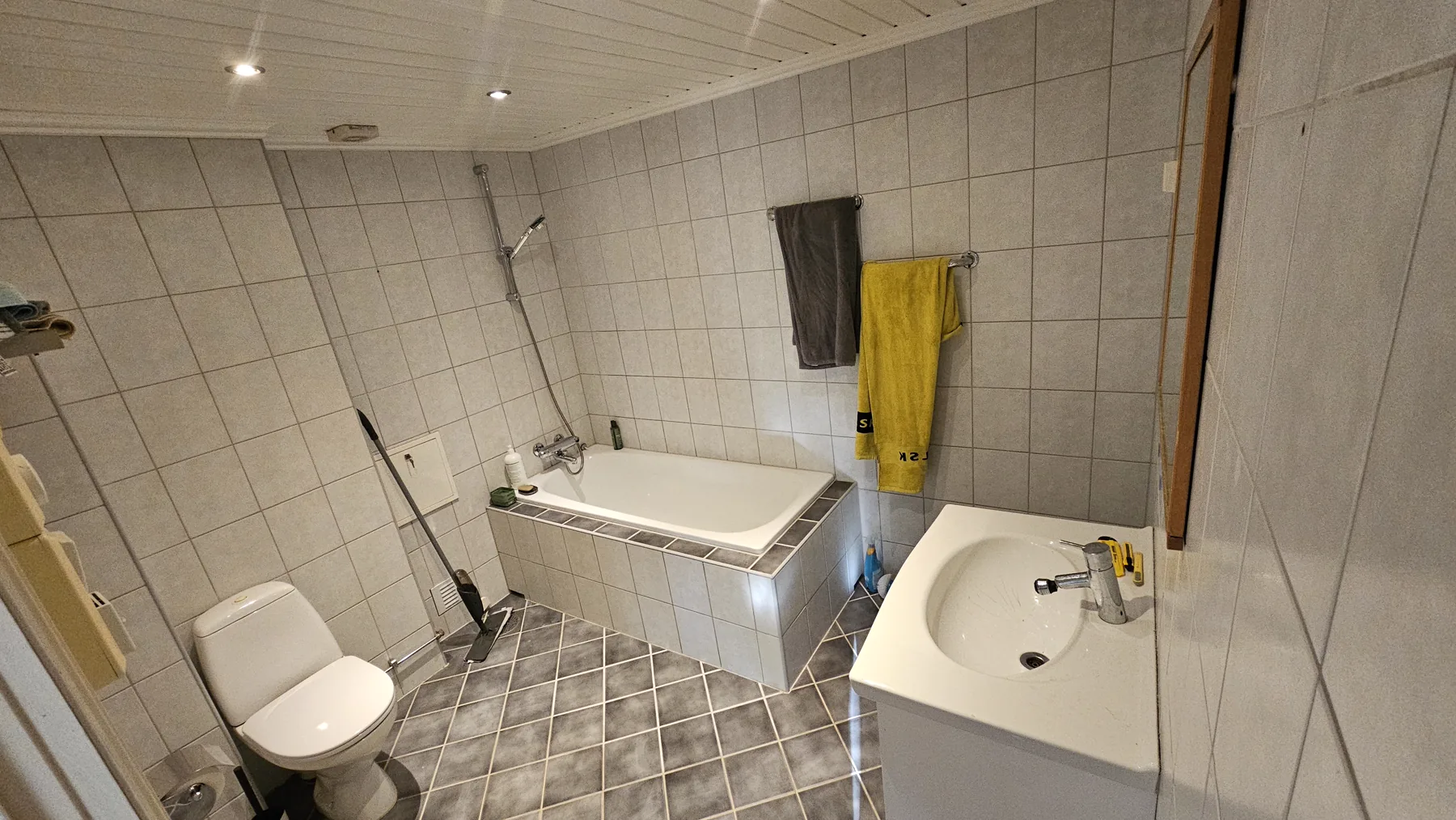 Grått flislagt bad før overflatefornying